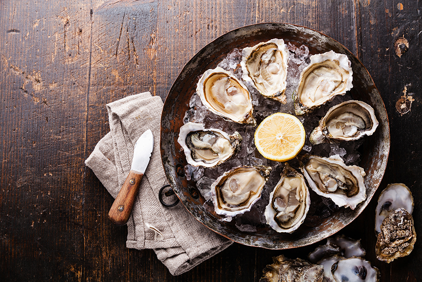 Fresh oysters on a wooden table.